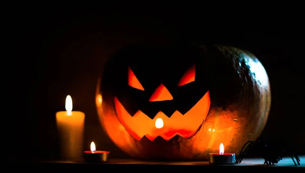 Velas, calabaza y araña sobre una mesa de madera —  Fotos de Stock