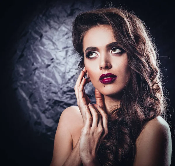 Glamorous young woman with evening makeup touching her face. — Stock Photo, Image