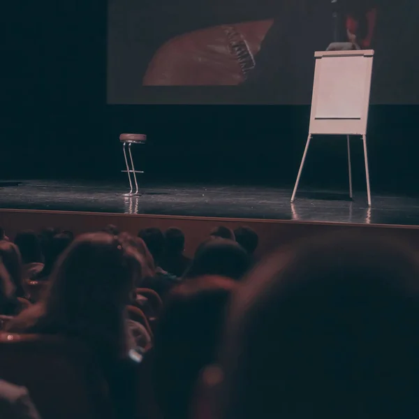 Экран, стульчик и флипчарт на трибуне в конференц-зале — стоковое фото