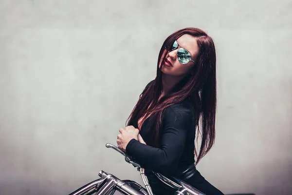 De cerca. mujer motociclista de pie cerca de una pantalla en blanco en el club —  Fotos de Stock