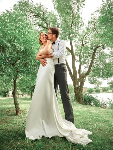 Em pleno crescimento. recém-casados abraçando na primavera Park — Fotografia de Stock