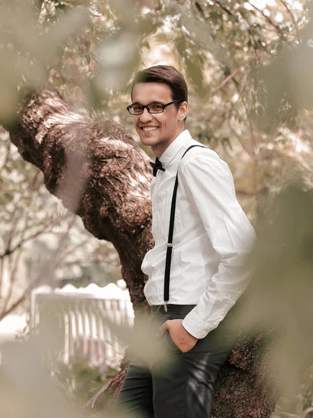 Smiling groom standing among the trees in the spring garden. — Stock Photo, Image