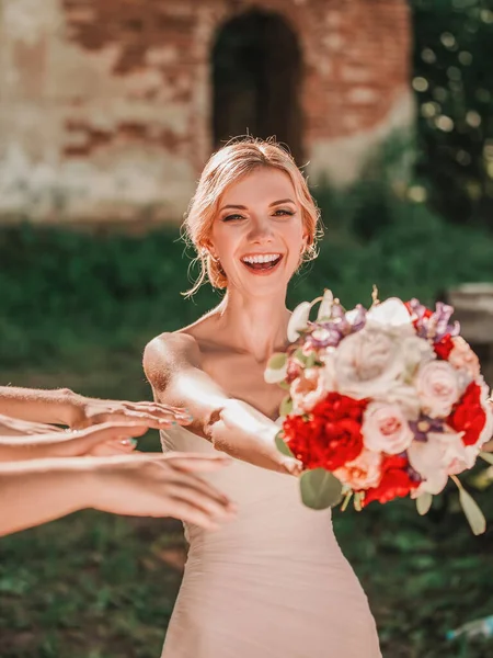 Noiva feliz entregando buquê de casamento para seus amigos — Fotografia de Stock