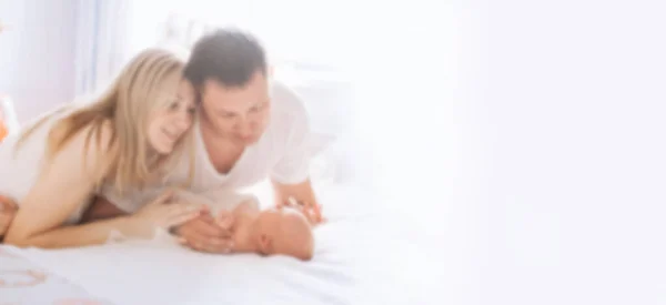 Portrait of a happy family with a newborn baby. background for text in blur with copy space — Stock Photo, Image