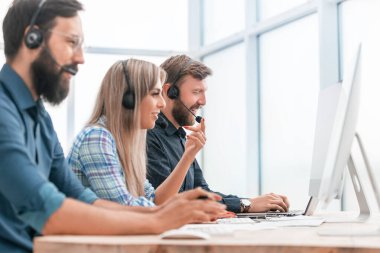 Çağrı merkezi operatörleri müşterilerle çalışmak için bilgisayar kullanır.