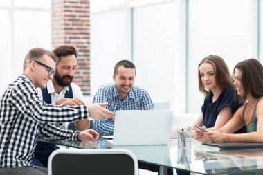 iş ekibi laptop ekranına bakıyor ve fikirlerini tartışıyor