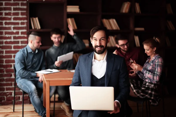 Empresário trabalhando em um laptop em um escritório criativo . — Fotografia de Stock