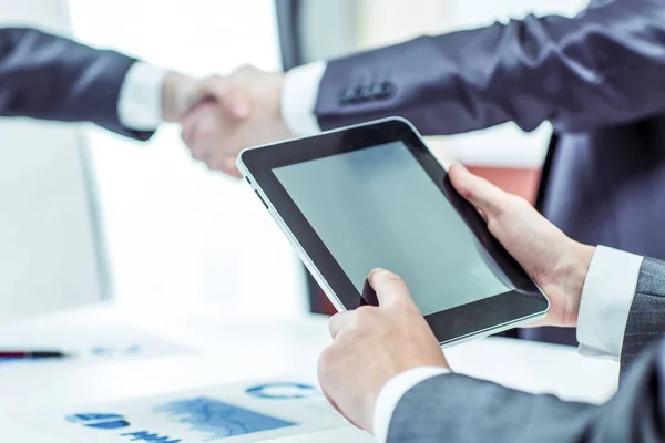 Бизнесмен с цифровым планшетом на фоне рукопожатия бизнес-партнеров — стоковое фото