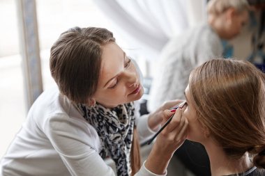 Bir güzellik salonunda sandalyede oturan genç bir kadın.