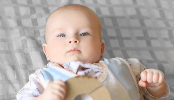 Yakın plan. Ekoseli bir boşluğa uzanmış güzel bir bebeğin portresi. — Stok fotoğraf