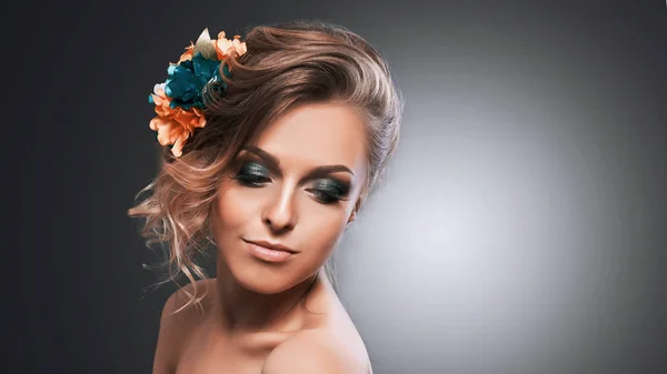 Giovane bella ragazza attraente con fiori nei capelli. Posa per la fotocamera . — Foto Stock
