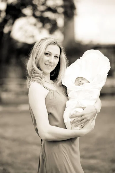 Young mom with a newborn baby outdoors — Stock Photo, Image