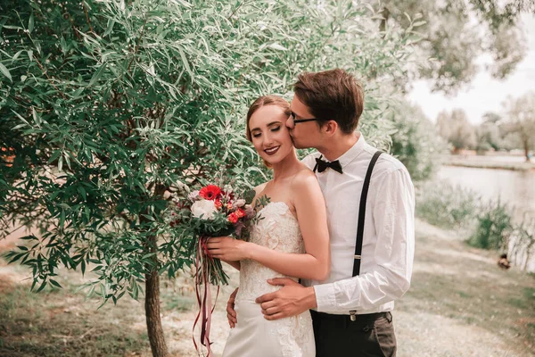 Glückliche Braut und Bräutigam beim Spaziergang im Stadtpark — Stockfoto