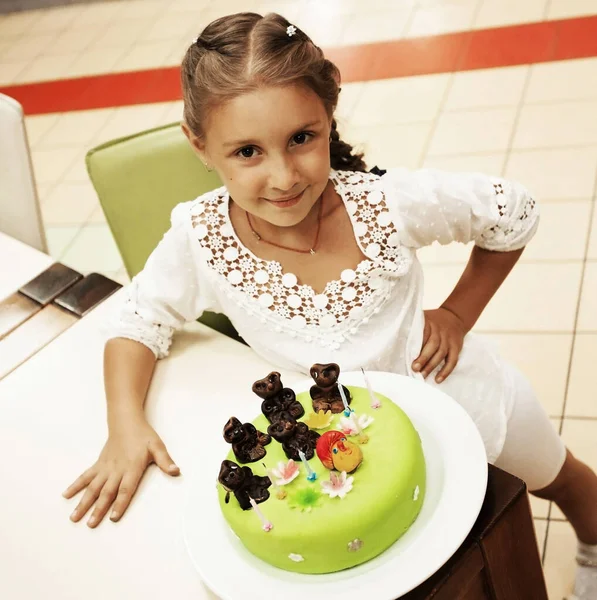 Little girl looking at cake in her birthday — Stock Photo, Image