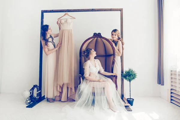 Mujer probándose vestido de novia con amigas divirtiéndose y tomando fotografías . —  Fotos de Stock