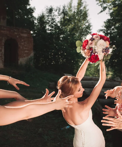 Lächelnde Braut wirft einen Strauß für ihre guten Freunde — Stockfoto