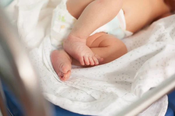 På nära håll. nyfött barn i spjälsängen — Stockfoto
