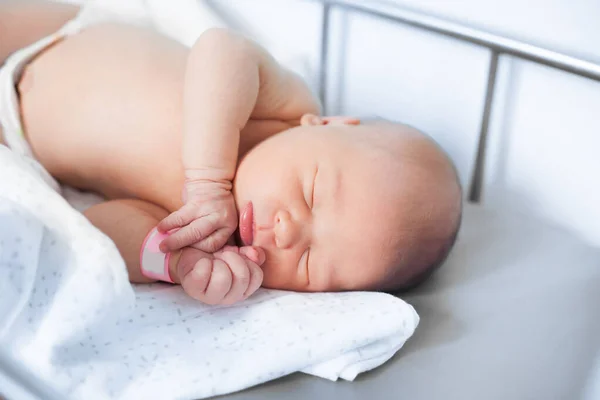 Söt nyfödd baby sover i en spjälsäng — Stockfoto