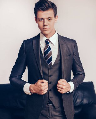 İş merkezinin odasında belgeli genç bir işadamı duruyor.