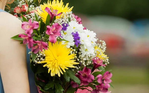 Cerrar. Joven sonriente con un ramo de flores — Foto de Stock