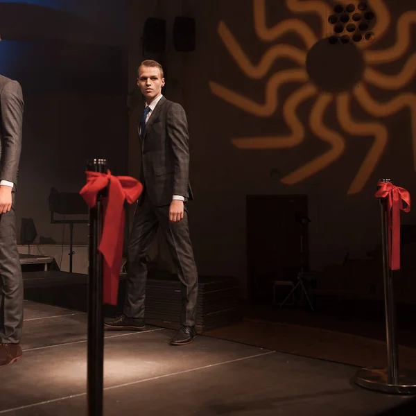 two attractive male models in a stylish suit during a fashion show