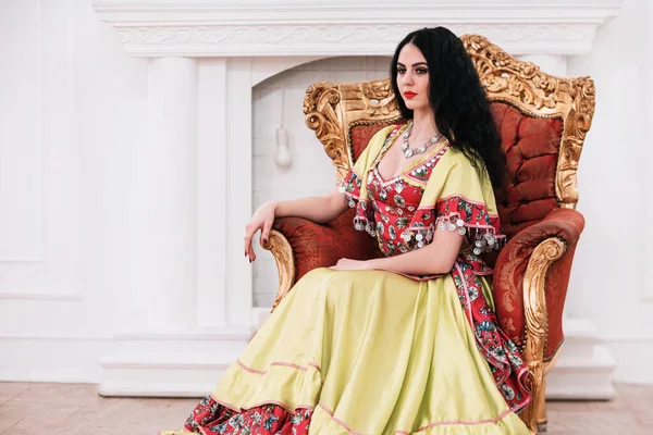 Beautiful young Gypsy woman sitting in a chair — Stock Photo, Image