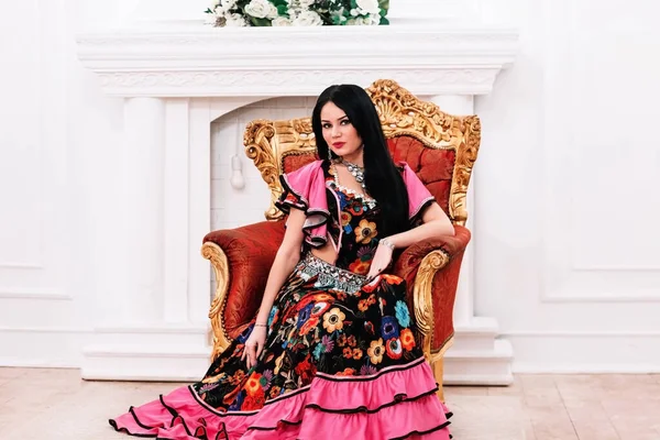Beautiful young Gypsy woman sitting in a chair — Stock Photo, Image