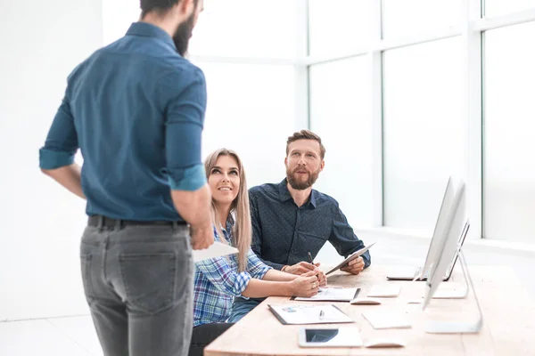 Gruppe von Mitarbeitern diskutiert Geschäftsdokumente am Arbeitsplatz. — Stockfoto