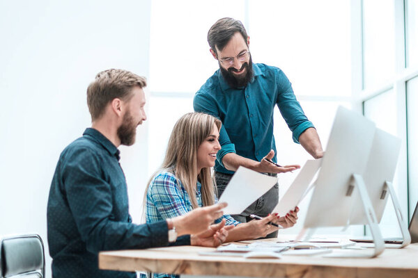 улыбающиеся сотрудники проверяют финансовые отчеты. бизнес концепция
