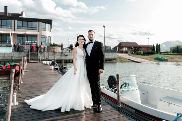 Happy bride and groom standing on the pier. — ストック写真