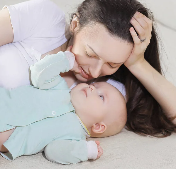 Close-up.mam en baby liggen op de bank en kijken naar de kwam — Stockfoto