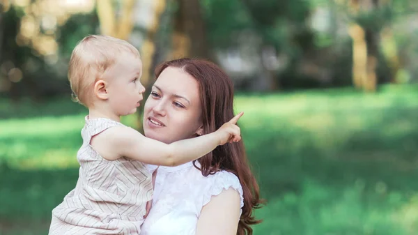 Cute little girl sitting in the arms of her mom. — Stock Photo, Image
