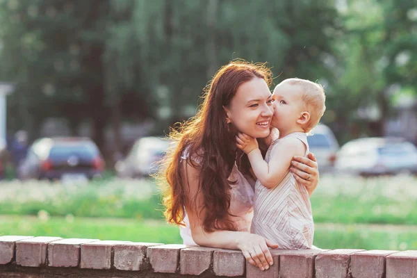 Little girl kisses her mommy while walking in the Park — Stock Photo, Image