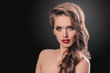 Akşam makyajıyla yüzüne dokunan göz kamaştırıcı genç kadın..