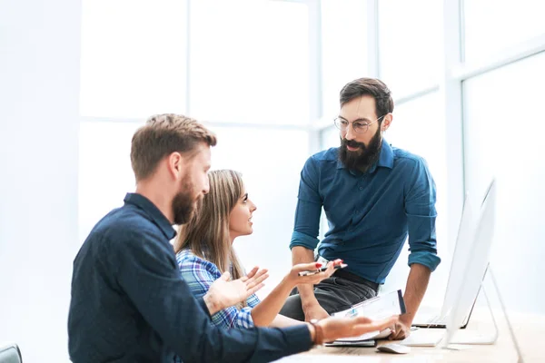 De près. un groupe de jeunes employés discutant des calendriers financiers — Photo