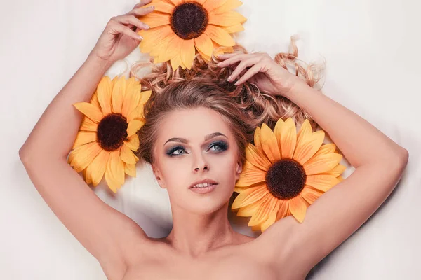 Bella ragazza sdraiata tra i fiori di un girasole — Foto Stock