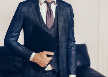 İş merkezinin koridorunda elinde pano olan ciddi bir iş adamı duruyor.