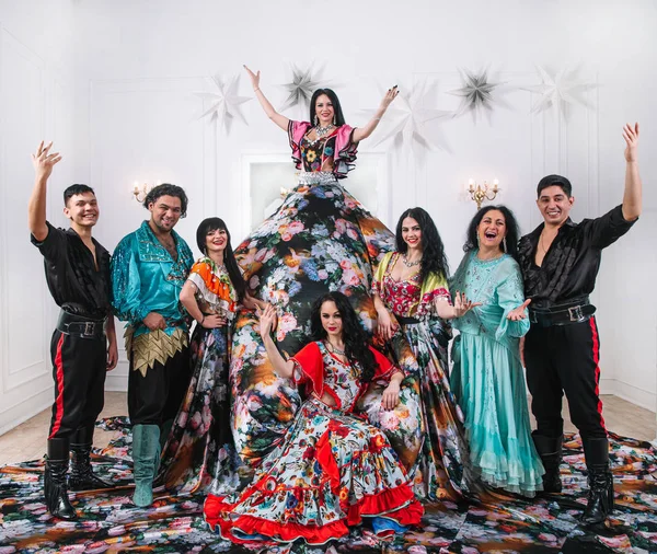 dance group in Gypsy folk costumes posing on stage.