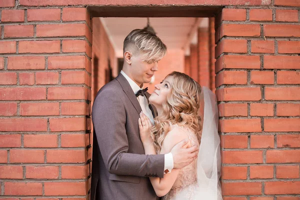 Gelukkig pasgetrouwd paar knuffelen elkaar tijdens het lopen — Stockfoto