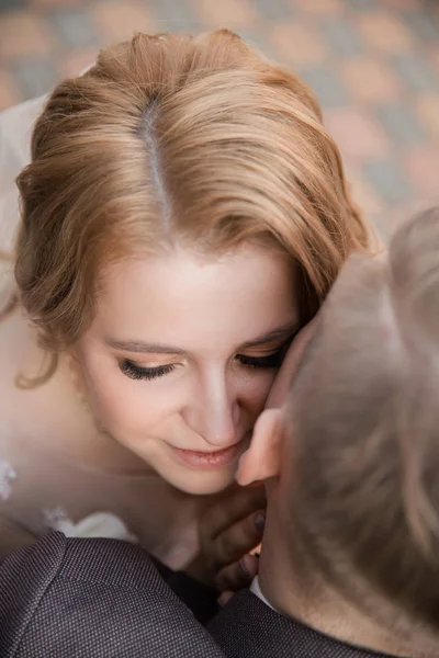 Ovanifrån. Glad brud och brudgum sitter på en bänk — Stockfoto