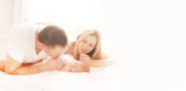 Blurred image for the advertising text. photo with copy space. happy parents looking at their newborn daughter. — Stock Photo, Image