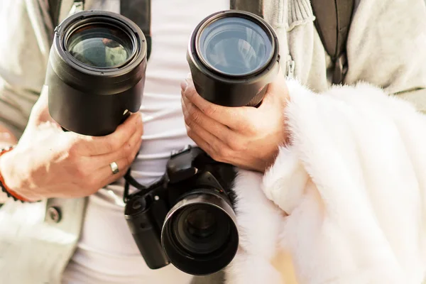 Câmera e lentes nas mãos de um jovem fotógrafo — Fotografia de Stock