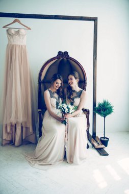 Eski bir sandalyede oturan düğün buketli nedime..