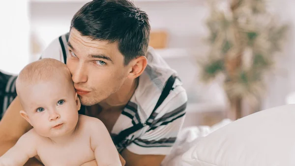 Padre joven jugando con el niño en el sofá — Foto de Stock