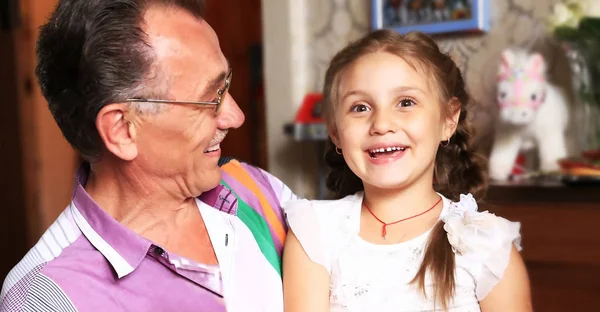 Granddaughter hugging grandfather .photo on the background of childrens room — Stock Photo, Image