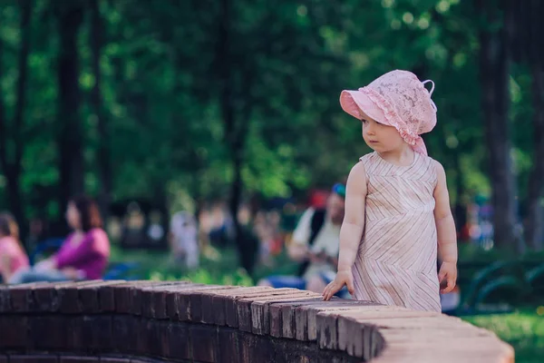 Young mother with a little daughter standing near the city fountain Stock Picture