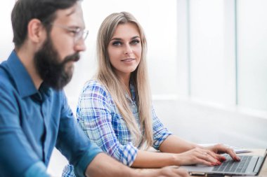 Çalışanlar modern bir ofiste birlikte çalışırlar.