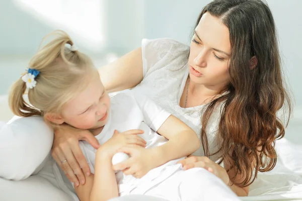 Moeder troost overstuur jonge dochter in de kinderkamer — Stockfoto