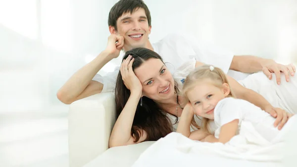 Glückliche Familie am Sonntag auf dem Sofa liegend. — Stockfoto