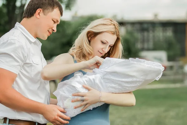 Heureux couple marié regardant leur nouveau-né — Photo